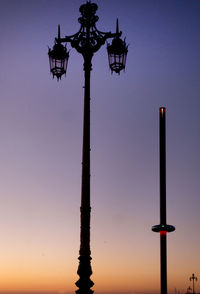 Low angle view of silhouette pole against sky