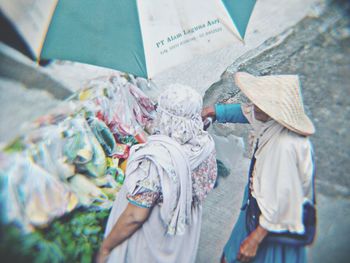 High angle view of people holding paper outdoors