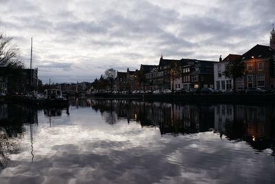 Reflection of houses in city against sky