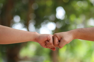 Cropped hand bumping fist outdoors