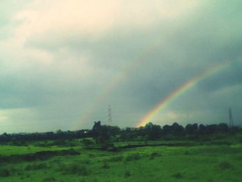 Scenic view of rainbow over landscape against sky