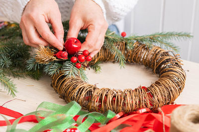 Cropped hands of woman holding christmas tree