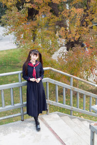 Full length of woman standing against railing