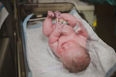 High angle view of cute naked baby lying in hospital