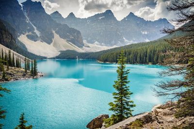 Scenic view of turquoise lake against rocky mountains during winter