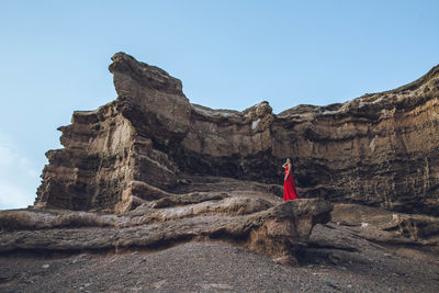 Low angle view of woman standing on rock