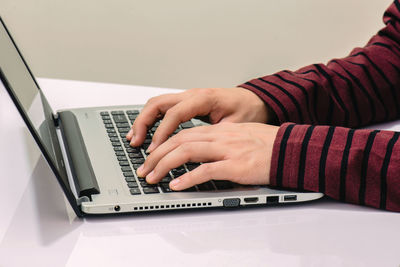 Midsection of man using laptop on table