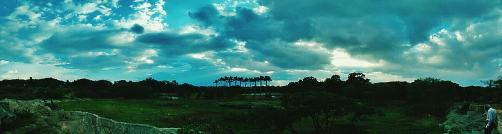 Scenic view of field against cloudy sky