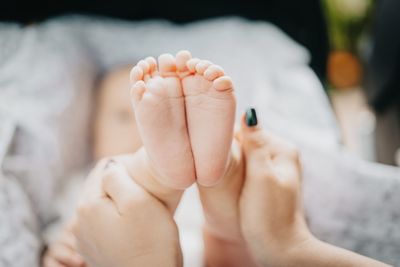 Cropped hands of woman holding baby foot