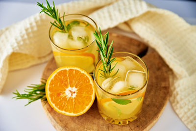 Orange fresh lemonadewith rosemaru in glass on table