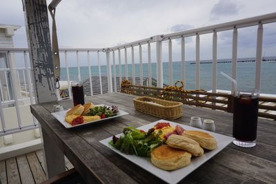 Food on table by sea against sky