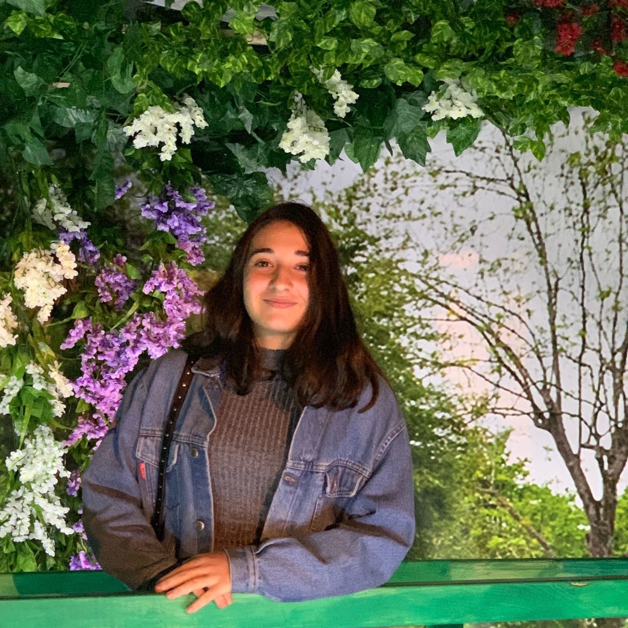 PORTRAIT OF A SMILING YOUNG WOMAN AGAINST BLUE WALL