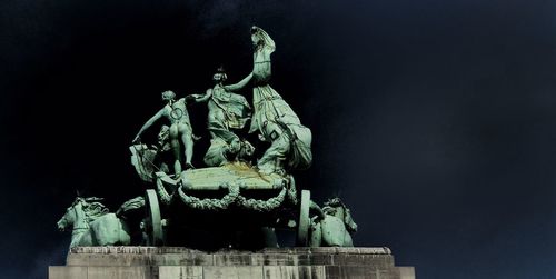 Low angle view of statue against sky at night