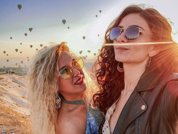 Portrait of women wearing sunglasses against sky during sunset