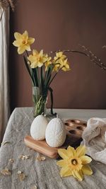 Traditional easter decor.burning soy candles in the shape of white eggs on a brown background