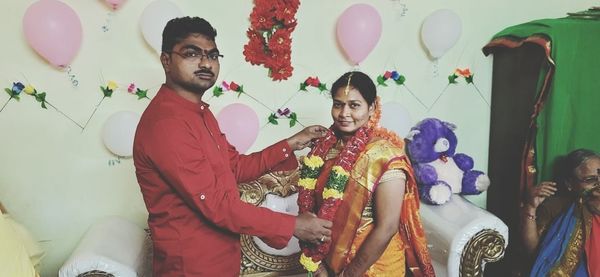 Young couple standing on balloons at home