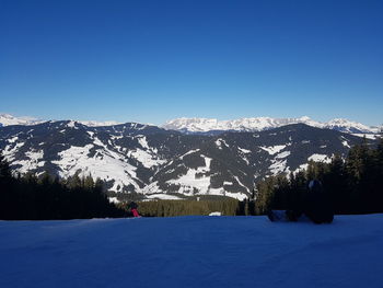 Scenic view of snowcapped mountains against clear blue sky