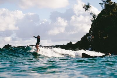 Man surfing in sea against sky