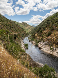 Scenic view of river amidst mountains against sky