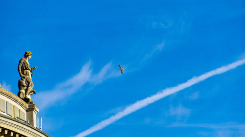 Low angle view of statue against blue sky