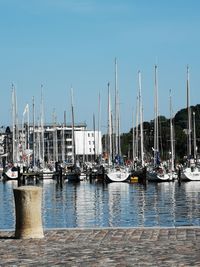 Boats moored at harbor against clear sky