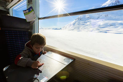 Child playing on bernina express train, engadin, switzerland