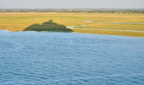 Scenic view of river amidst field against sky