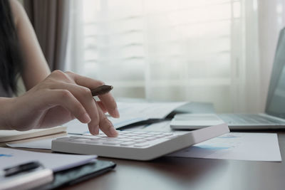 Midsection of man using laptop on table