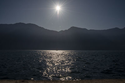 Scenic view of sea against bright sun