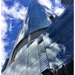 Low angle view of modern building against cloudy sky