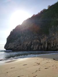 Scenic view of sea by cliff against sky