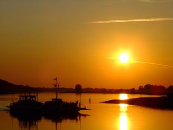 Silhouette harbor against sky during sunset