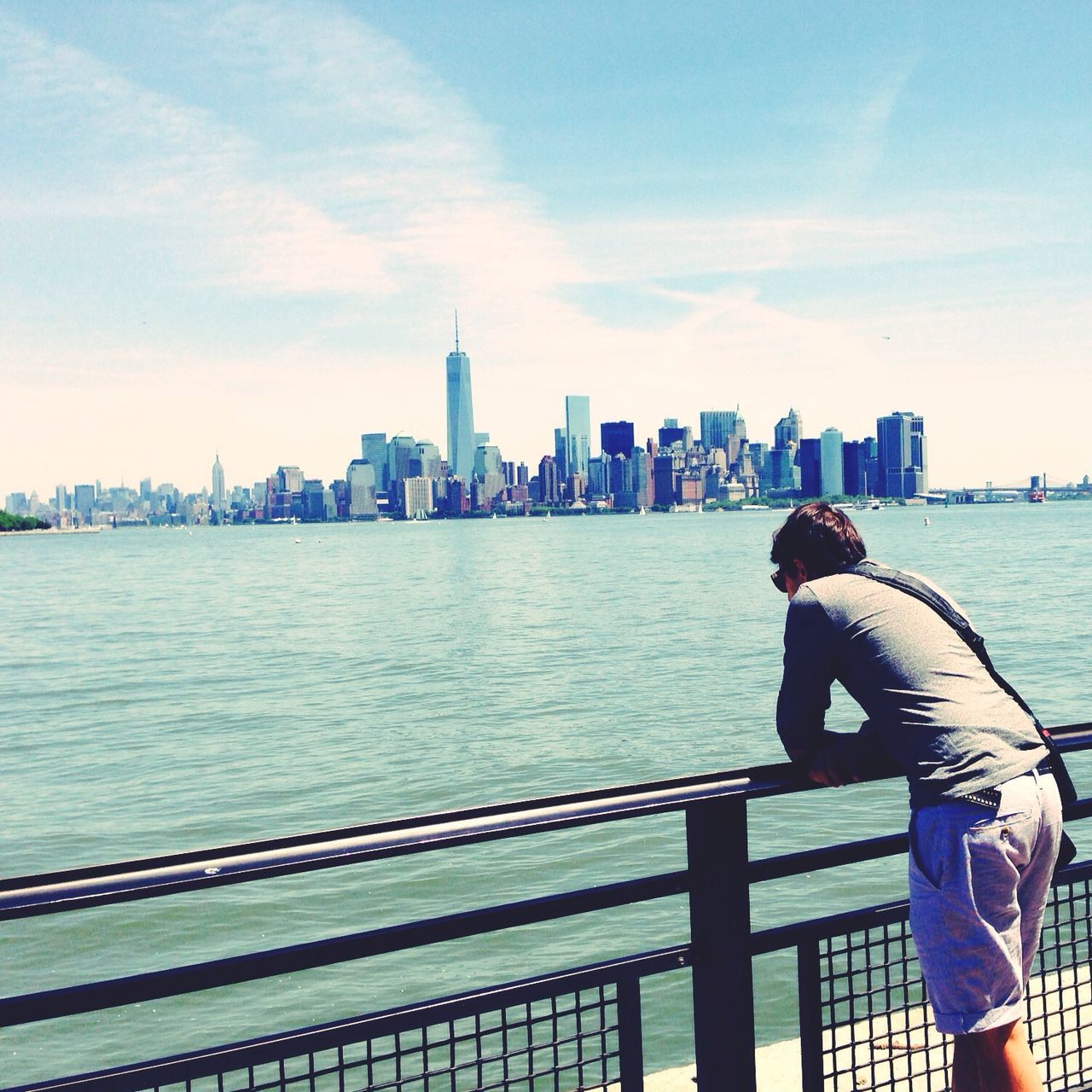 water, city, built structure, building exterior, architecture, river, lifestyles, leisure activity, cityscape, sky, sea, skyscraper, rear view, railing, standing, men, tower, city life