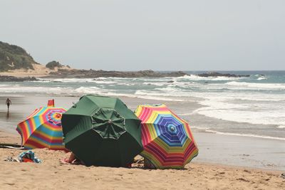 Umbrellas on beach against clear sky