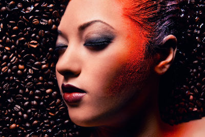 Close-up of young woman with coffee beans