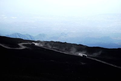 Man riding bicycle on road against sky