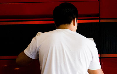 Rear view of man standing against wall