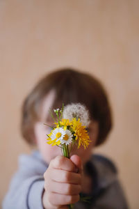 Close-up of boy holding flowers