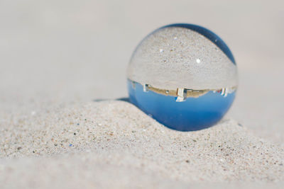 Close-up of crystal ball on sand