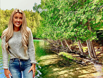 Portrait of a smiling young woman against plants