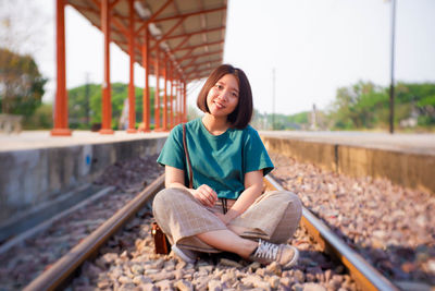 Girl sitting on railroad track