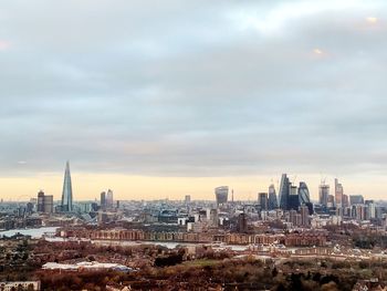 View of cityscape against cloudy sky