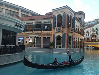 Boats in canal amidst buildings in city