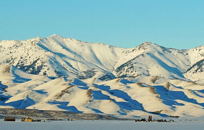 Scenic view of snowcapped mountains against clear blue sky