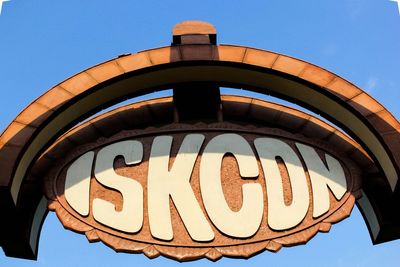 Low angle view of information sign against blue sky