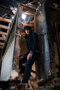 Low angle view of woman standing on wooden wall