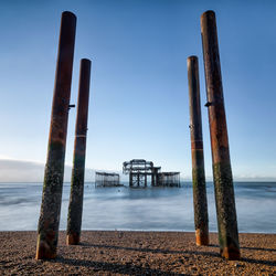 Brighton west pier on pebble beach against clear sky