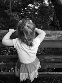 High angle view of girl standing on wooden railing