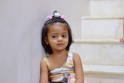 Cute girl looking away while sitting on steps