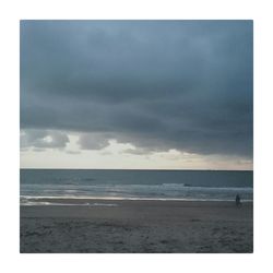 Scenic view of beach against cloudy sky